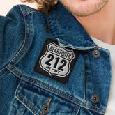 Man wearing a denim jacket with a patch on a beige background